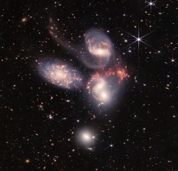 Five swirling galaxies against a starry background.