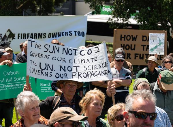 rally of people holding signs voicing scepticism a<em></em>bout climate change