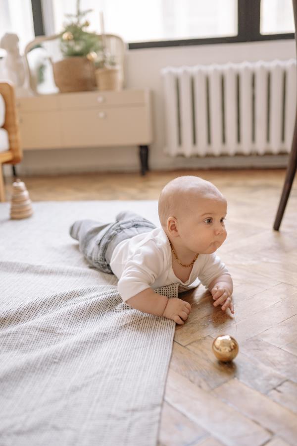 Baby crawling over rug on floor of a room